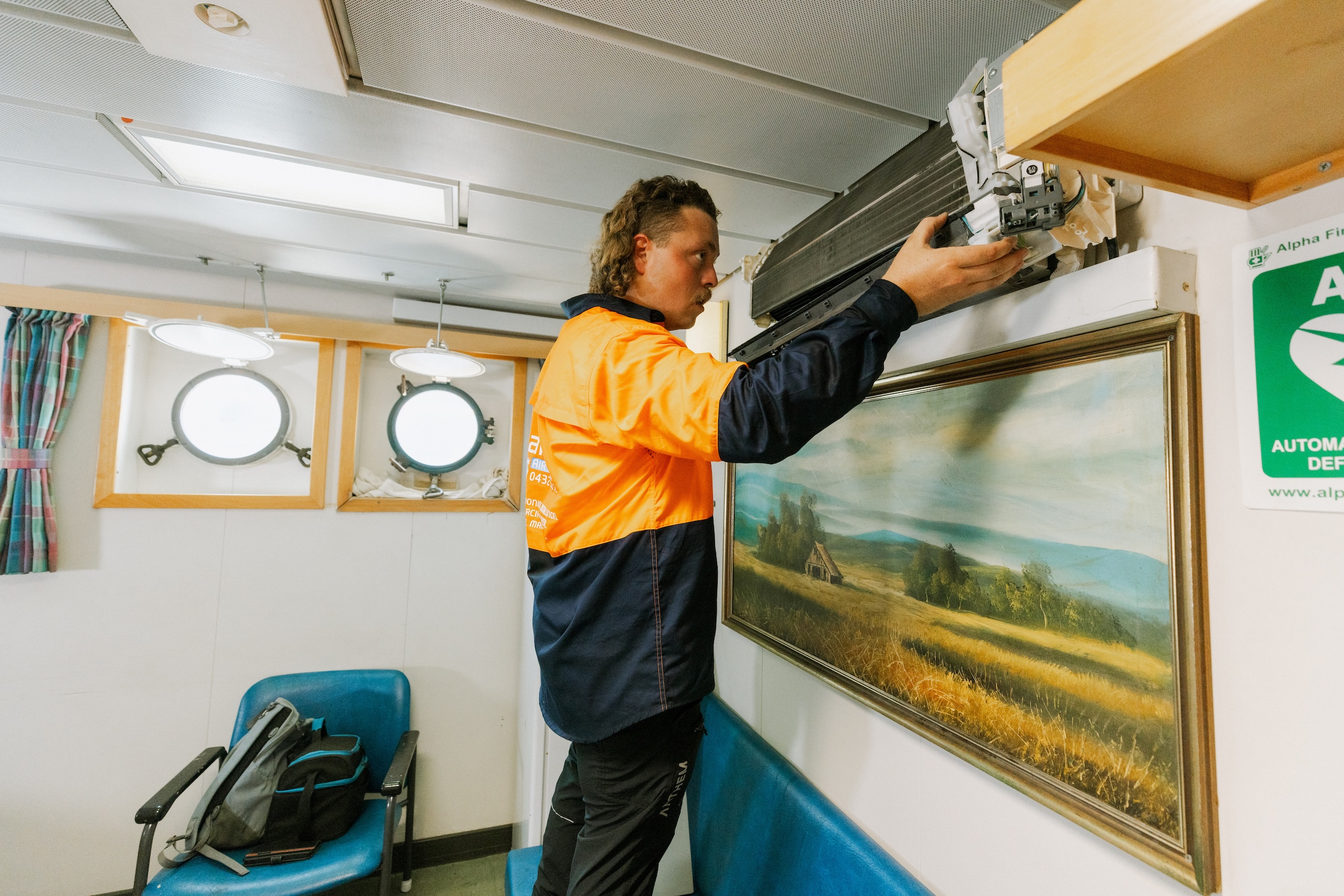 Technician servicing vessel cabin air conditioning