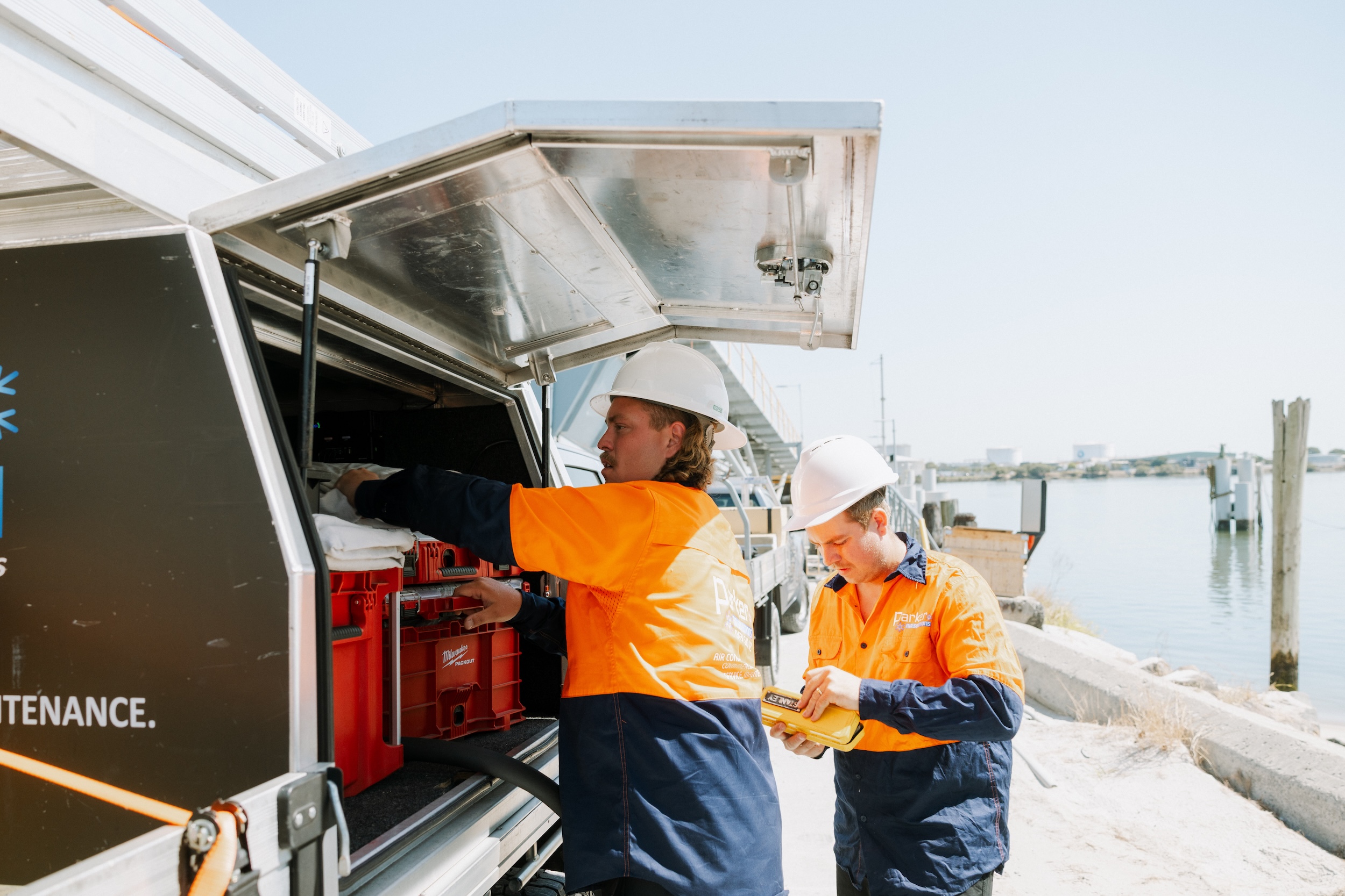 Marine AC technician getting tools from ute at port