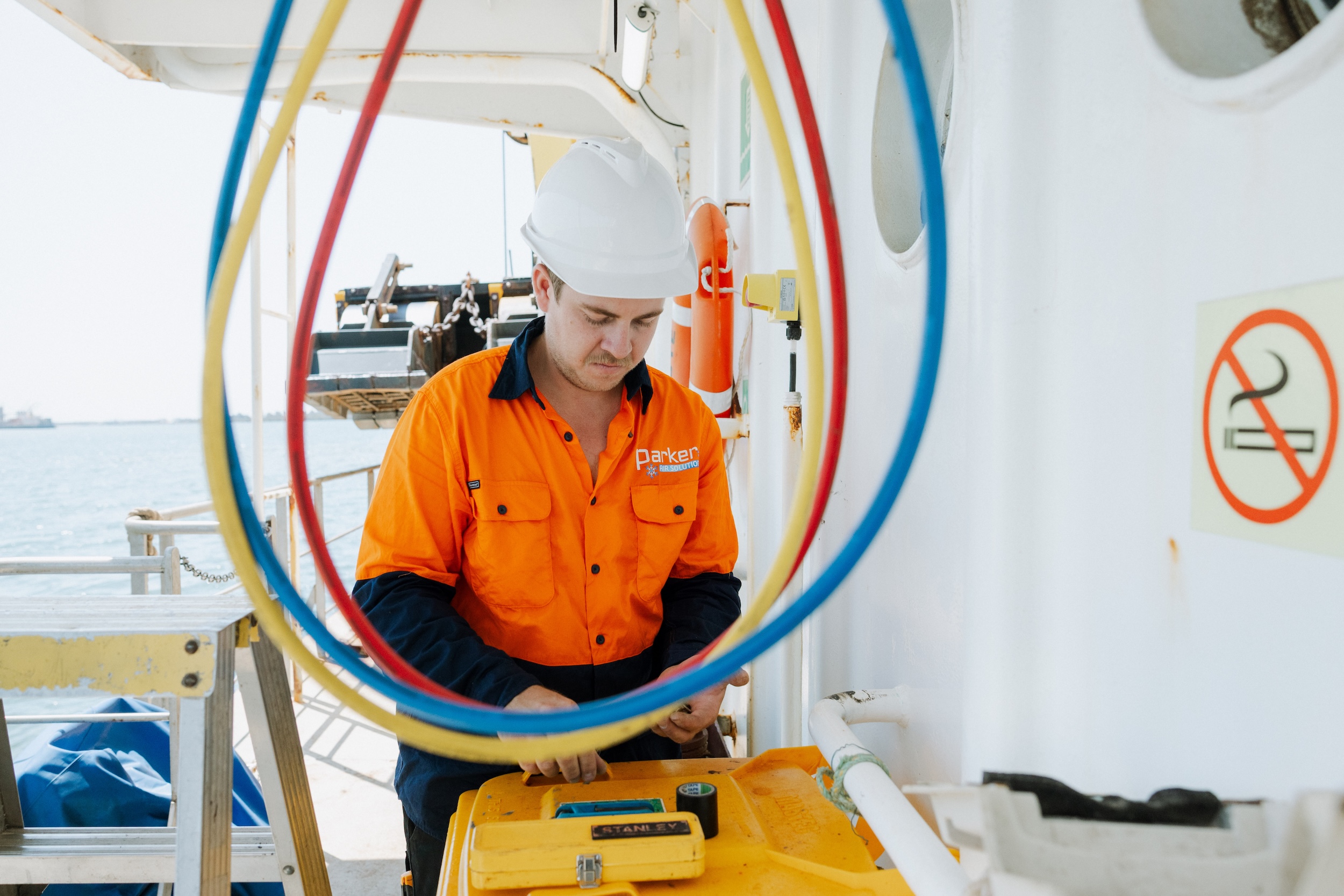 Vessel aircon technician working with hoses