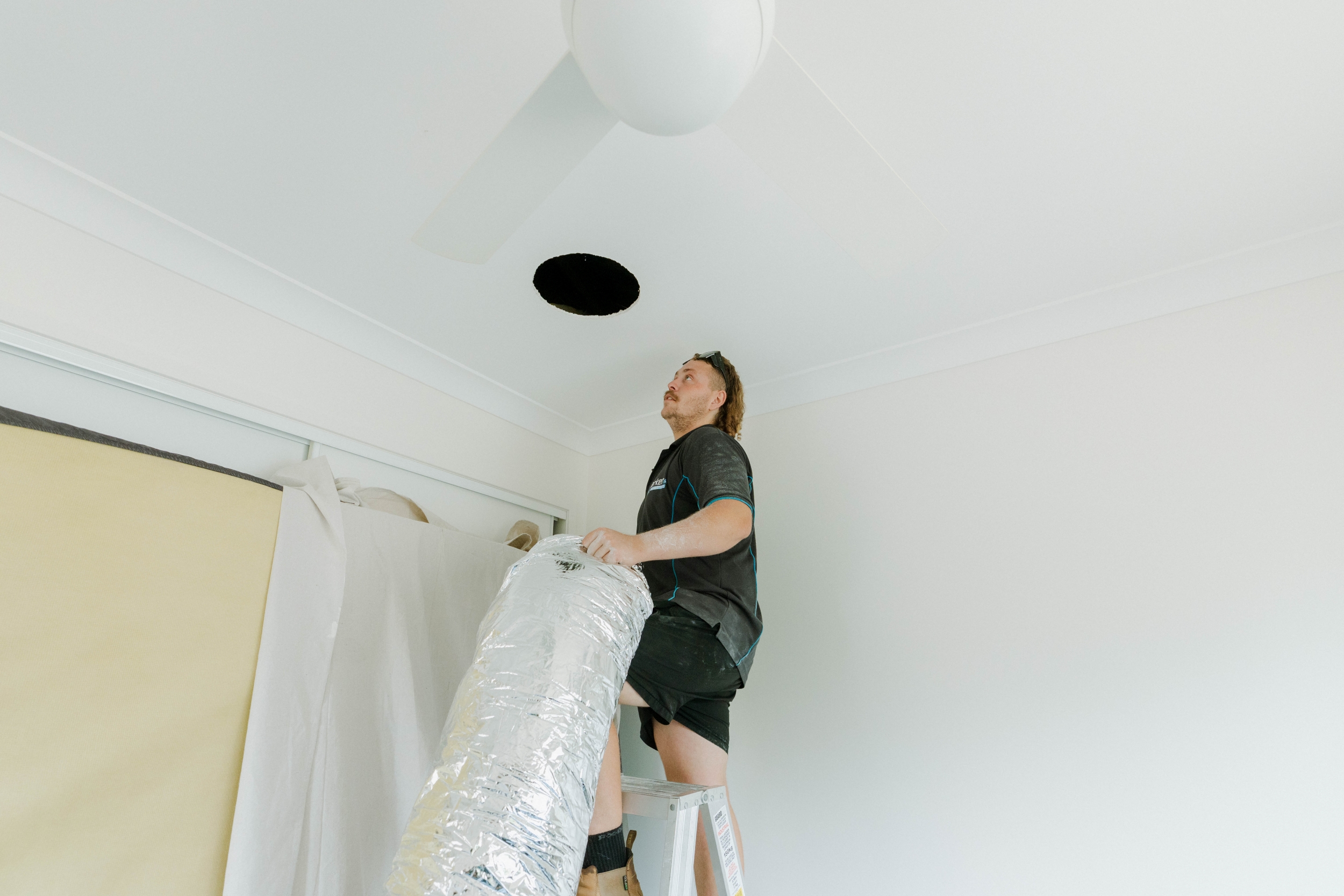 Feeding insulated flexible ductwork through ceiling cavity during ducted aircon install