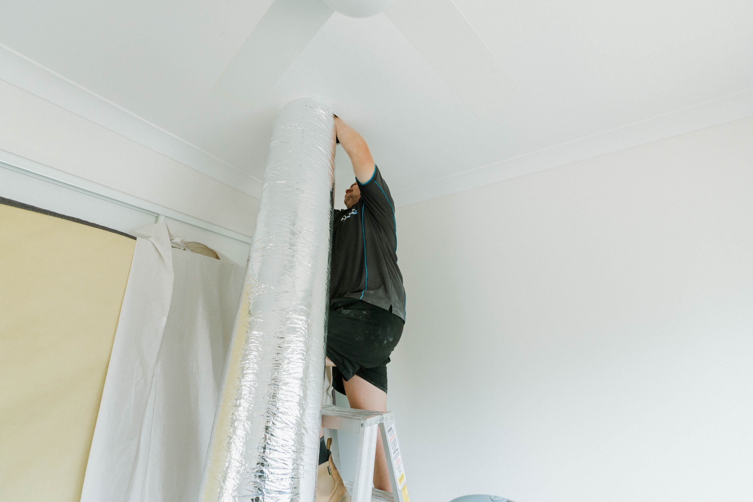 Installing insulated flexible duct into ceiling cavity for ducted air conditioning