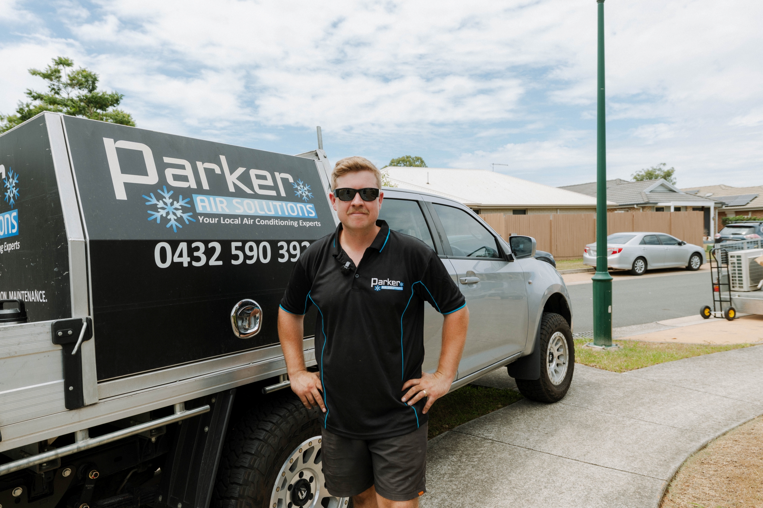 Parker Air Solutions team member with branded ute ready for air conditioning service