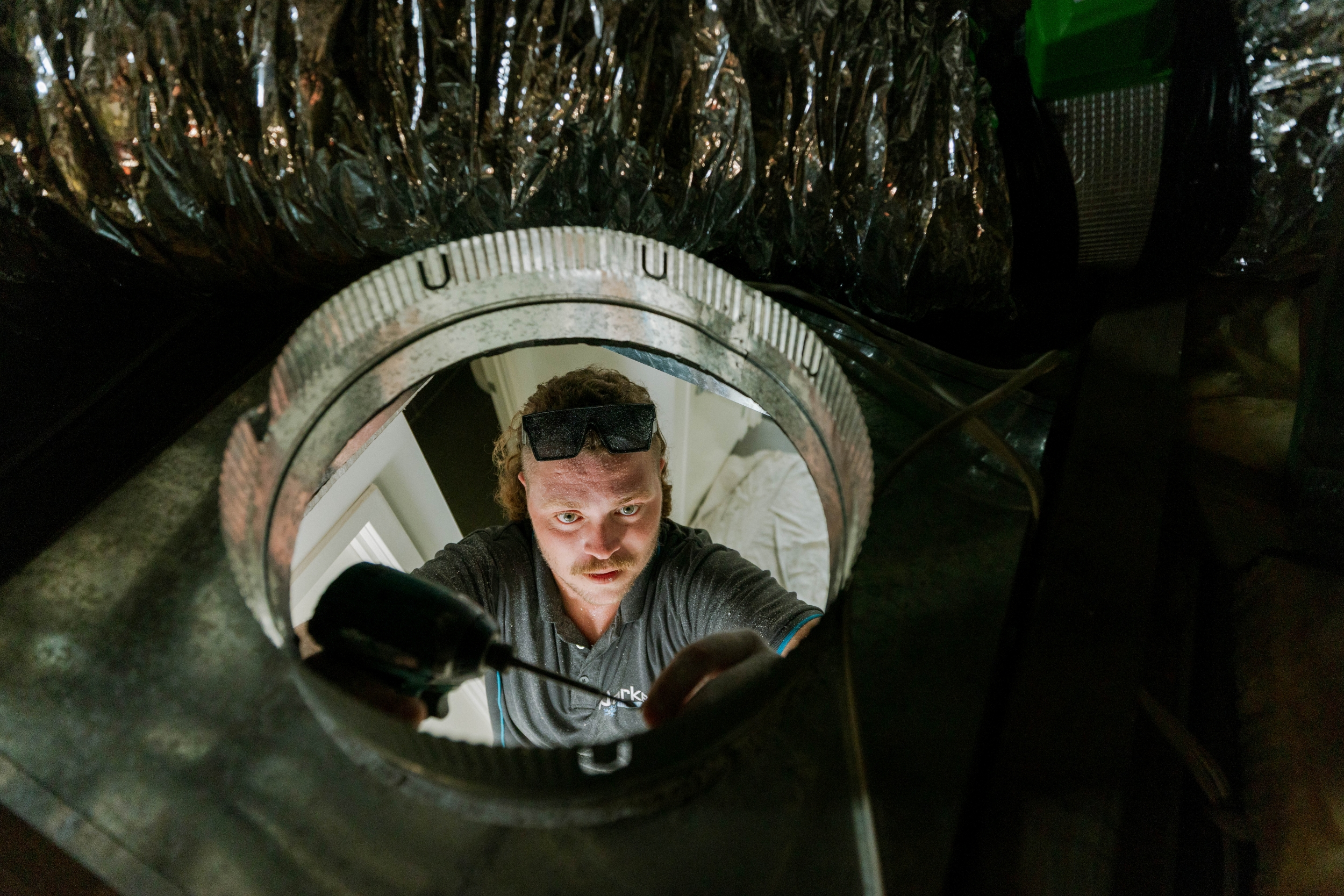 Technician view from inside ductwork during ducted air conditioning installation