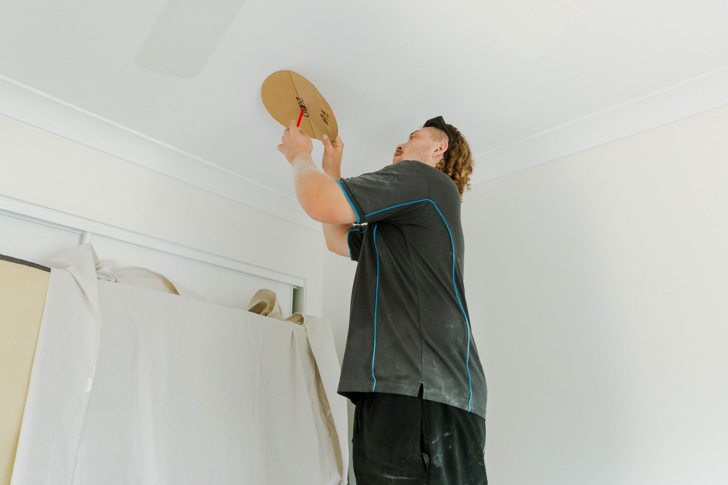 Parker Air Solutions technician marking ceiling vent position during ducted aircon installation