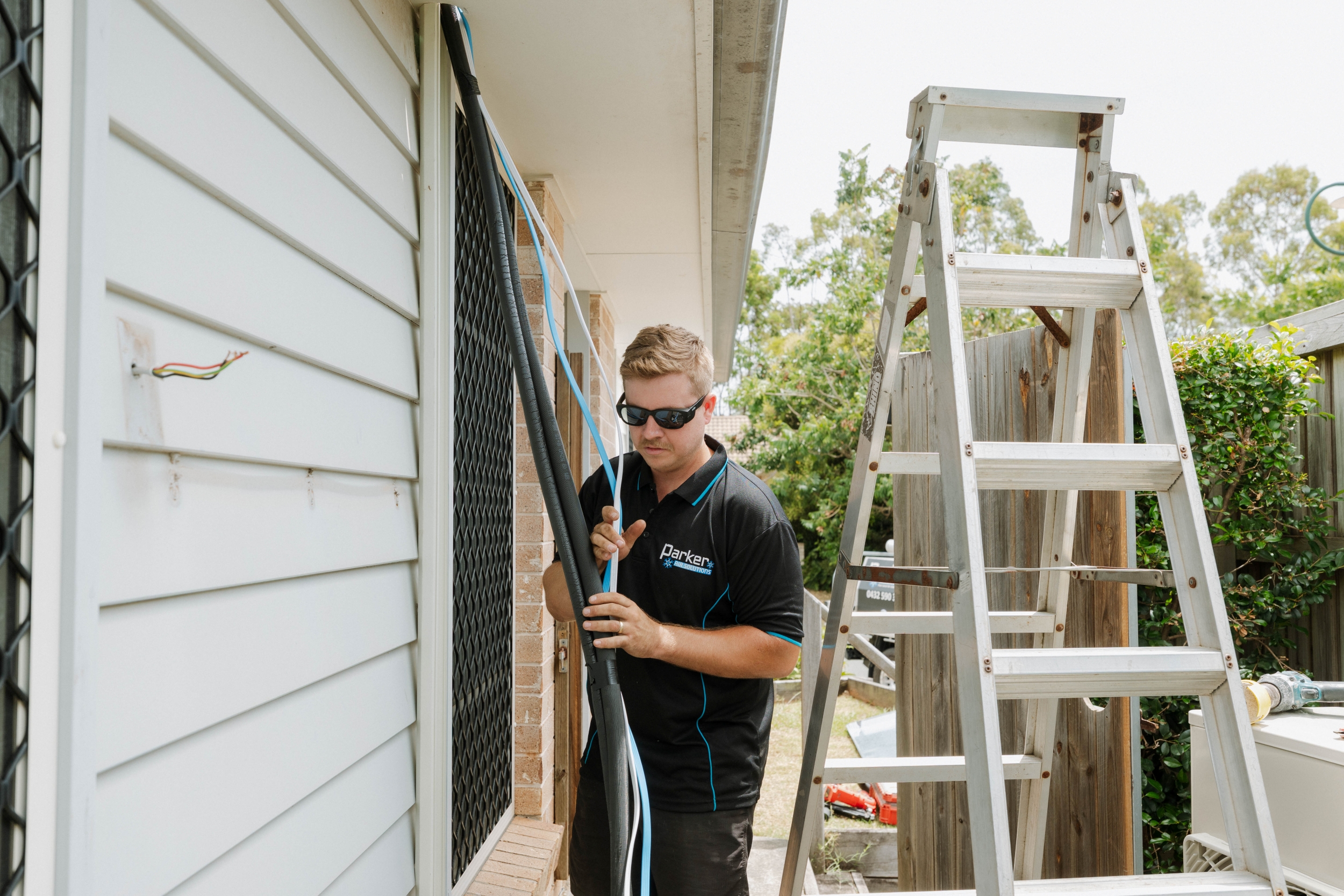 Parker Air Solutions technician routing copper refrigerant pipes for ducted air conditioning